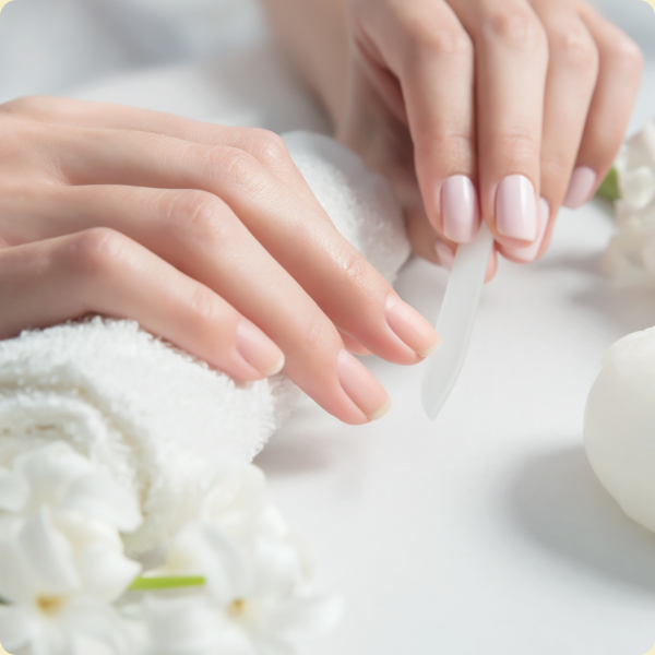 Gentle hand care with a nail file, soft towel, and fresh white flowers for a spa-like experience