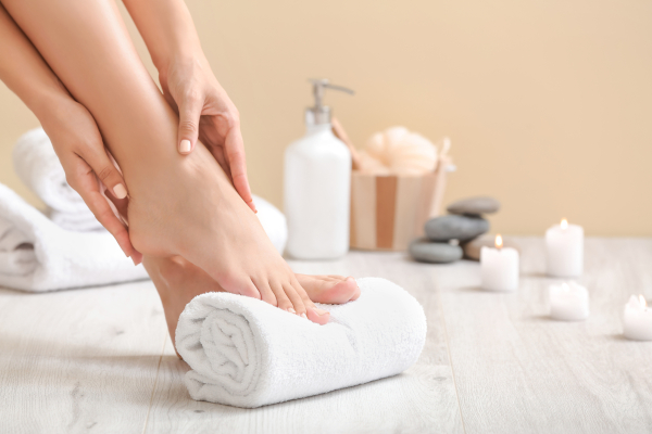 A woman gently holds her feet